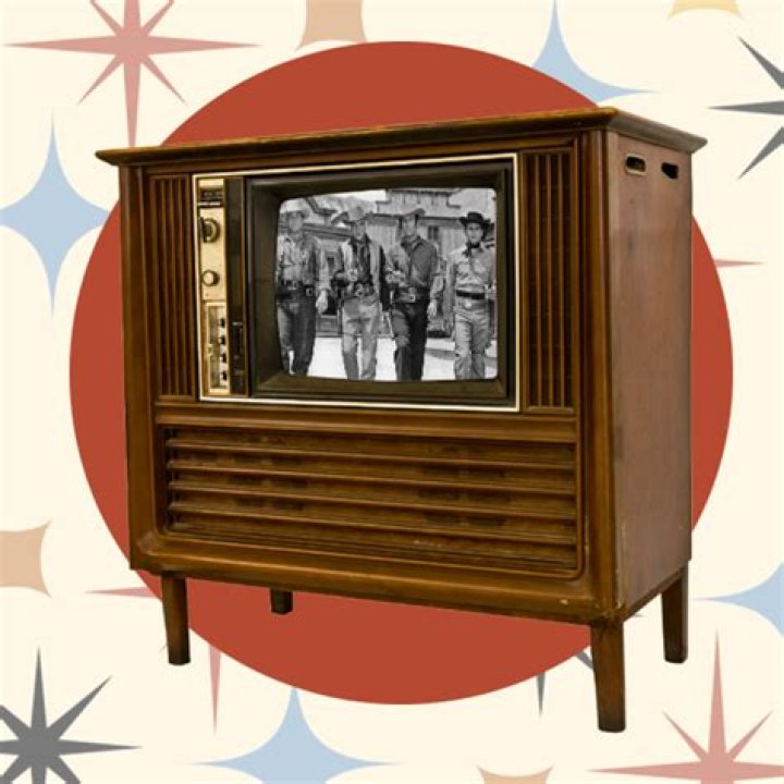 an old tv with two people kissing on the screen and microphones in